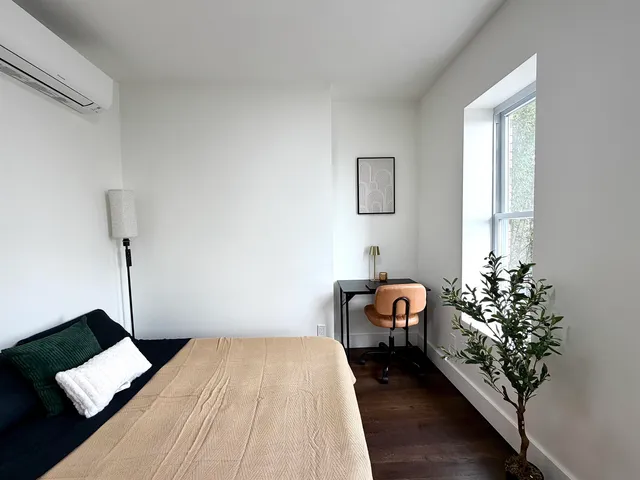 a bed sitting in a bedroom next to a window