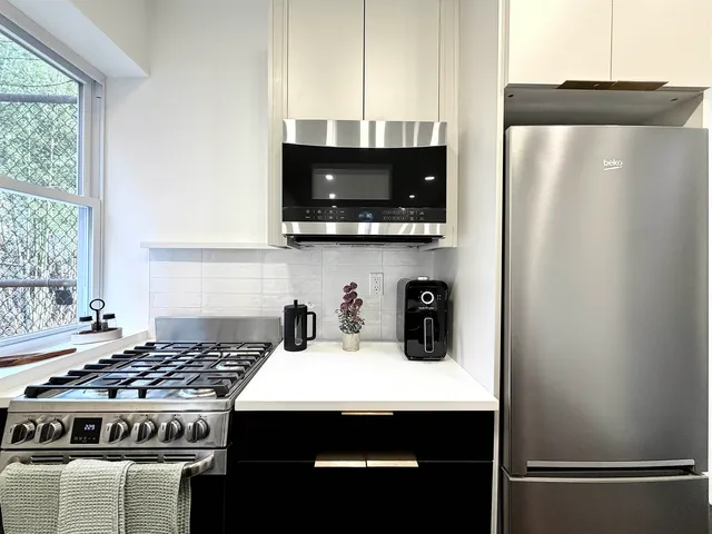 a kitchen with stainless steel appliances a stove a microwave and a sink