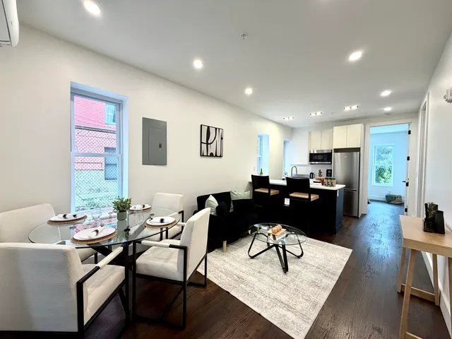 a living room with lots of furniture and view of kitchen