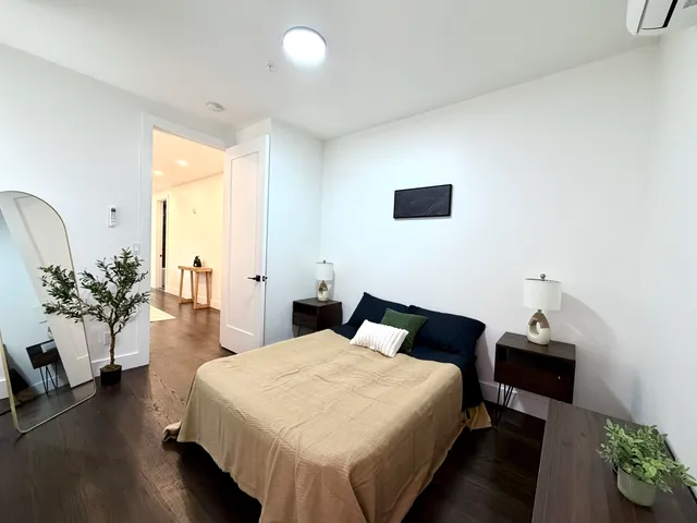 a bedroom with a bed and a potted plant