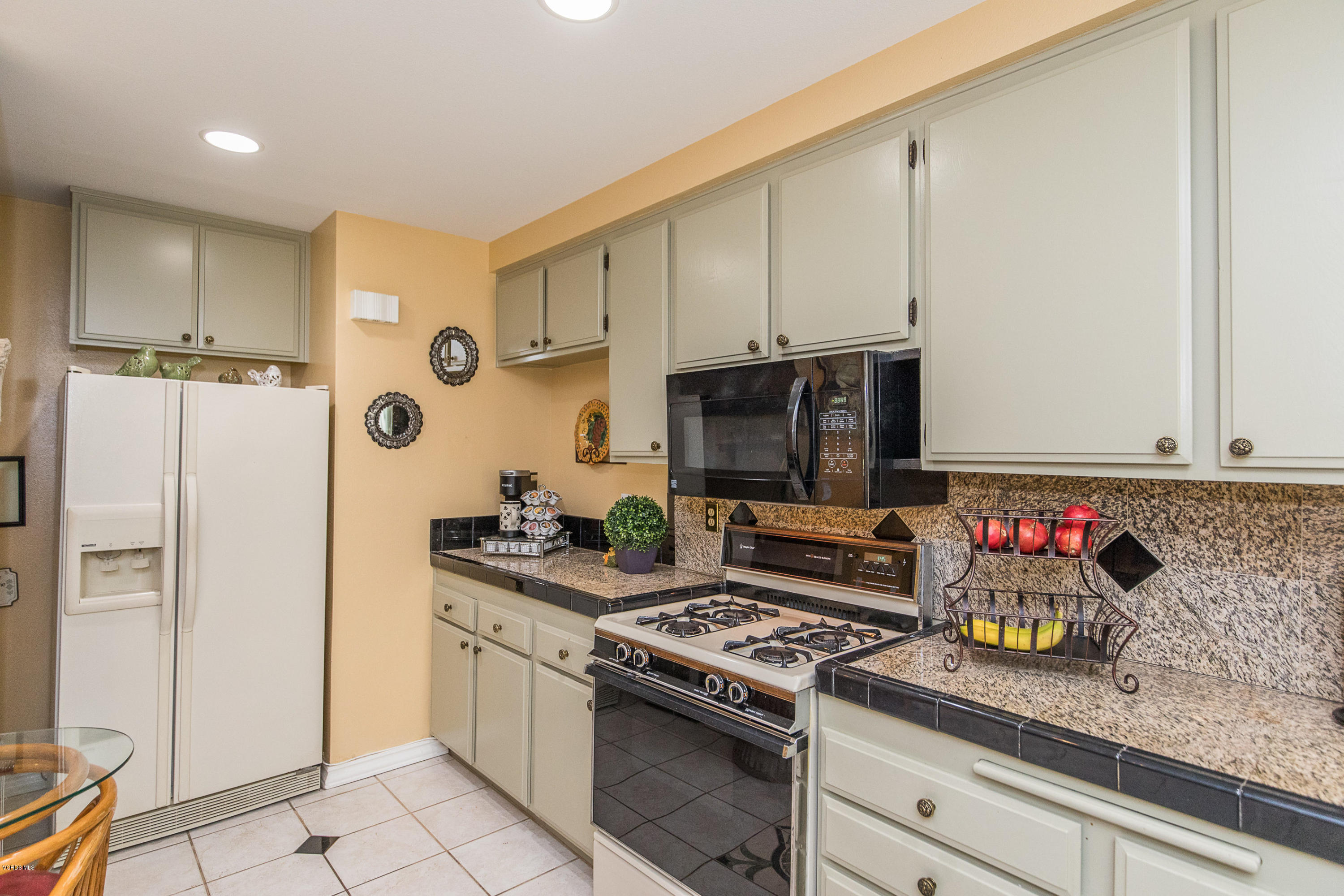13208 East Quail Summit Road Moorpark, CA 93021 - Photo 9 of 36 a kitchen with stainless steel appliances granite countertop a stove a refrigerator and a microwave