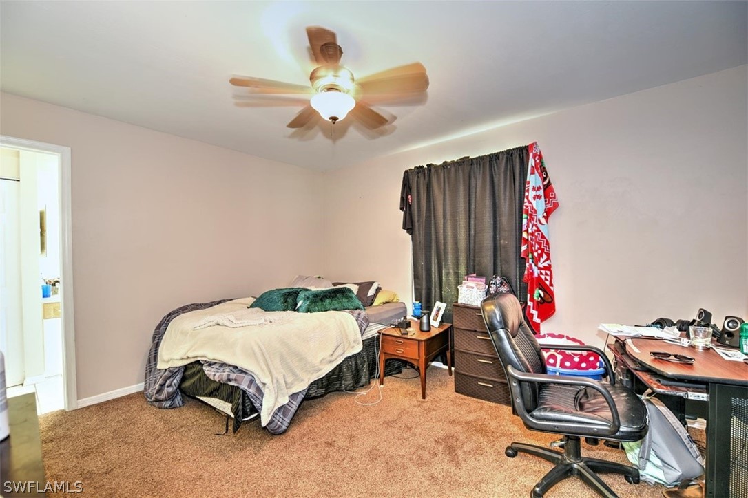 19004 Tangerine Road Fort Myers, FL 33967 - Photo 12 of 26 a bedroom with a bed and a chandelier