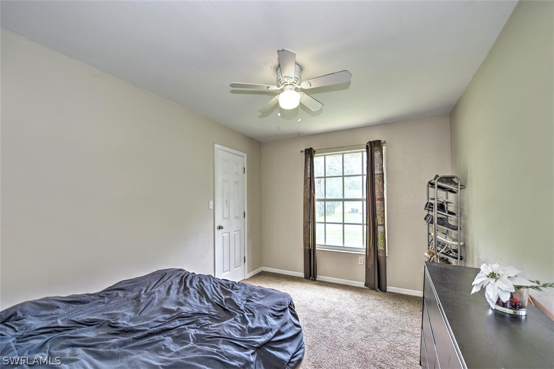 19004 Tangerine Road Fort Myers, FL 33967 - Photo 15 of 26 a bedroom with a bed and a chandelier