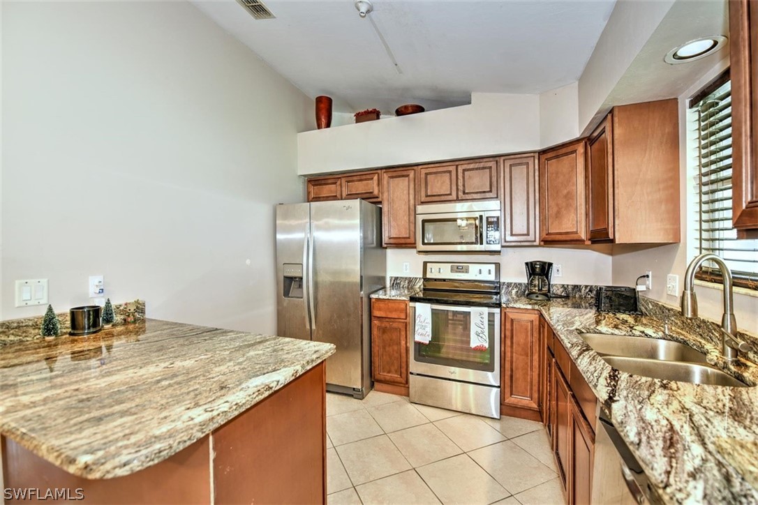 19004 Tangerine Road Fort Myers, FL 33967 - Photo 3 of 26 a kitchen with stainless steel appliances granite countertop a sink stove and refrigerator