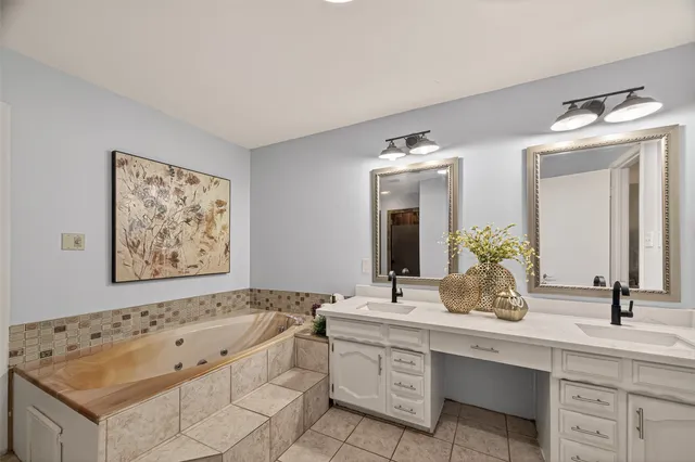 a bathroom with a tub sink and mirror
