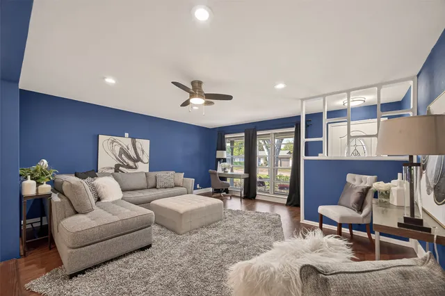 a living room with furniture ceiling fan and a window