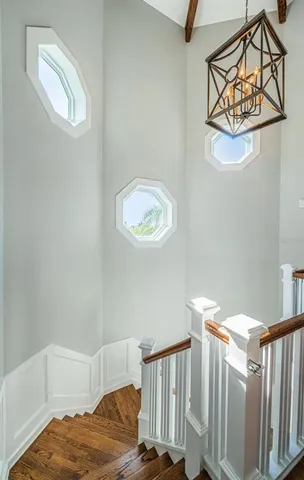 a living room with couches and kitchen view with wooden floor