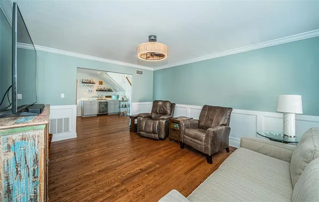 a view of a patio with table and chairs potted plants and floor to ceiling window