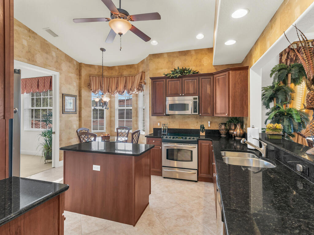 7869 Hawthorne, Unit 303 Naples, FL 34113 - Photo 15 of 52 a kitchen with stainless steel appliances granite countertop a sink stove and refrigerator