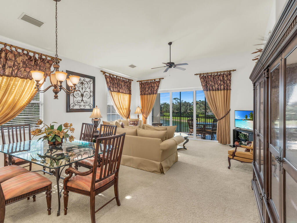 7869 Hawthorne, Unit 303 Naples, FL 34113 - Photo 16 of 52 a dining room with furniture a chandelier and wooden floor