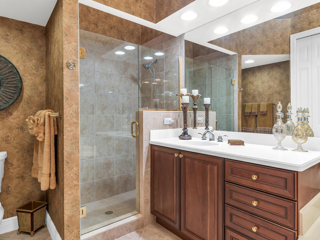 7869 Hawthorne, Unit 303 Naples, FL 34113 - Photo 25 of 52 a bathroom with a sink a mirror and a shower