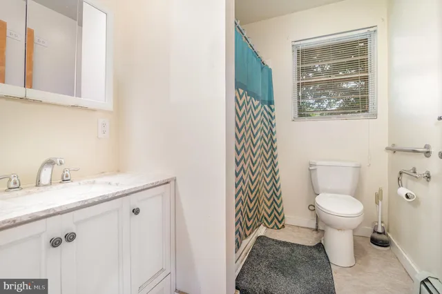 a bathroom with a granite countertop toilet and a sink