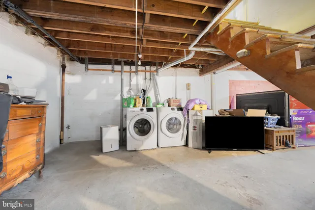 a utility room with dryer washer and stair