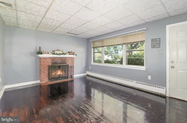 a living room with a fireplace and a floor to ceiling window