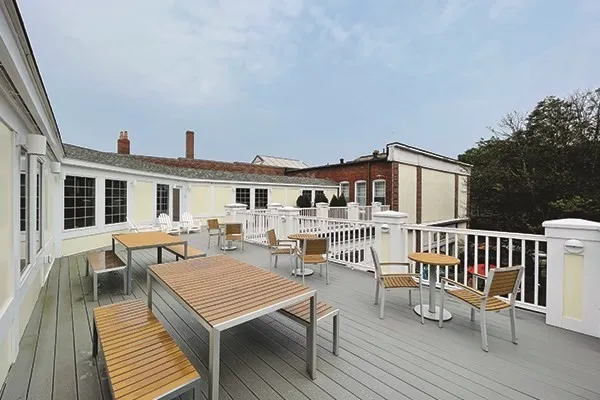 a terrace of a house with wooden floor outdoor seating and yard in the back