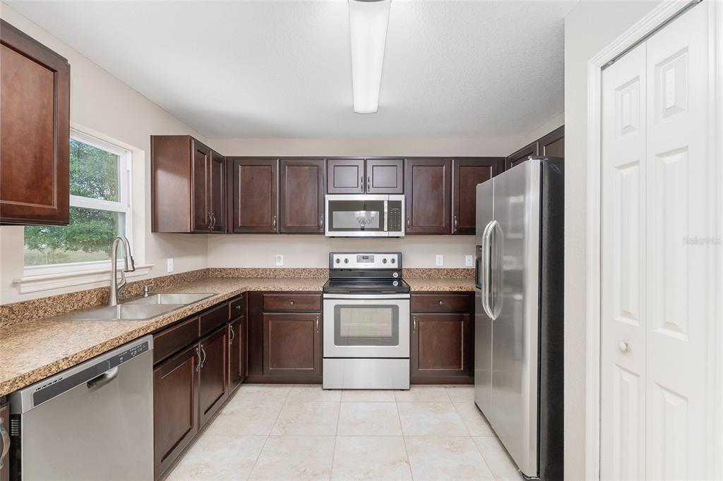 2 Hemlock Loop Drive Ocala, FL 34472 - Photo 9 of 28 a kitchen with stainless steel appliances granite countertop a stove top oven a sink and dishwasher