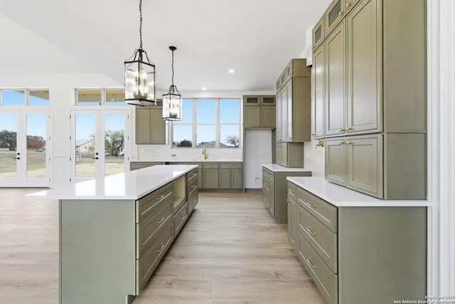 a large kitchen with stainless steel appliances kitchen island granite countertop a sink and cabinets