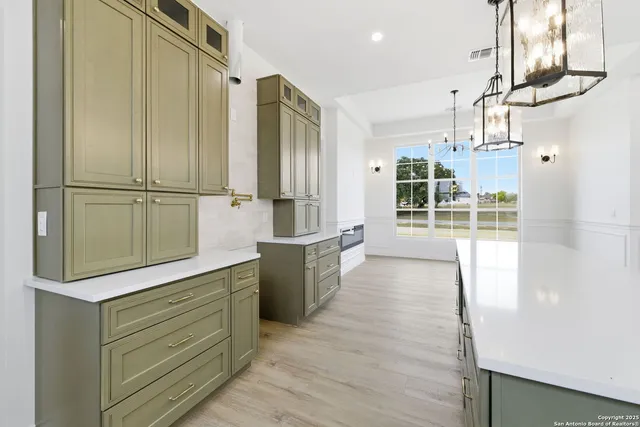 a kitchen with kitchen island a counter top space wooden floor and appliances