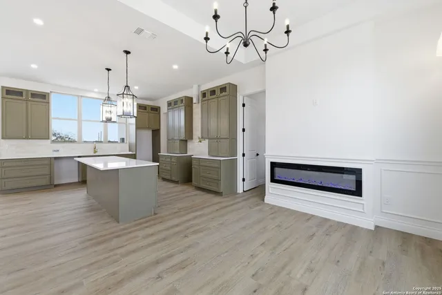 a view of kitchen with stainless steel appliances granite countertop cabinets and wooden floor