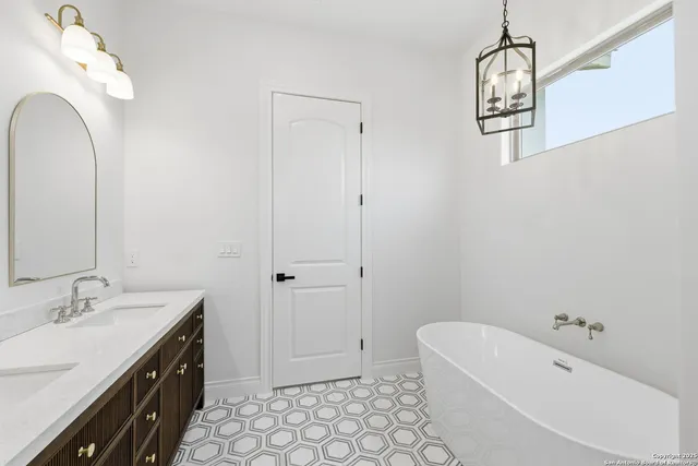 a spacious bathroom with a double vanity sink mirror and bathtub