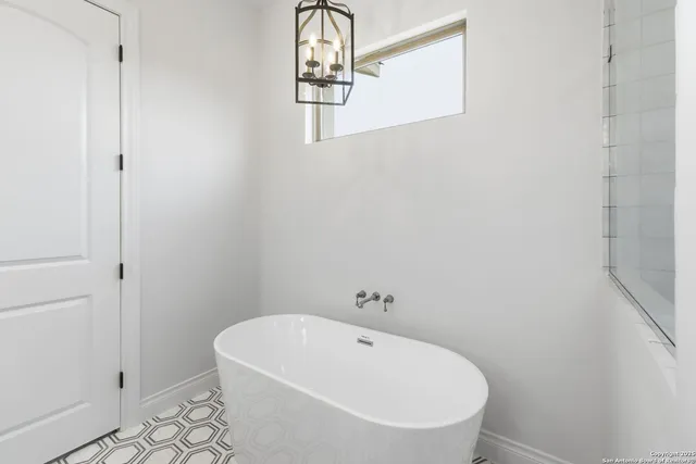 a white bath tub sitting next to a white sink and vanity