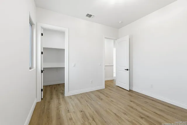 a view of an empty room with wooden floor