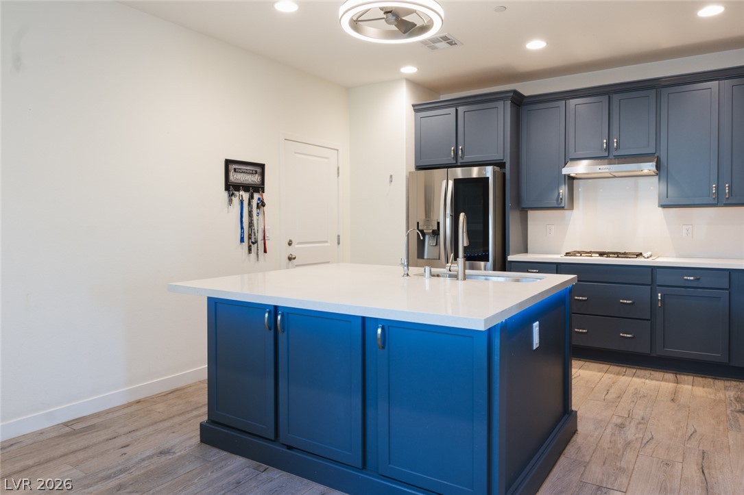 920 East Sunset Road Henderson, NV 89011 - Photo 9 of 33 A contemporary kitchen showcasing rich blue cabinetry and a central island.