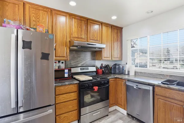 a kitchen with stainless steel appliances granite countertop a stove a refrigerator and a sink