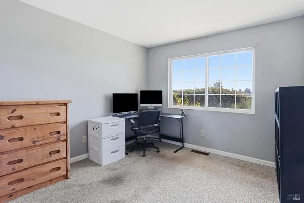 a view of a workspace with furniture and a window