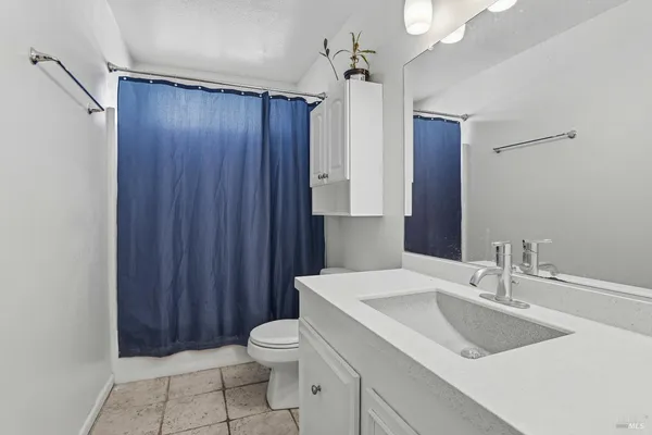 a bathroom with a sink vanity mirror and toilet