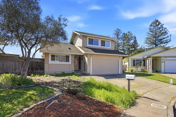 a front view of a house with a yard and trees