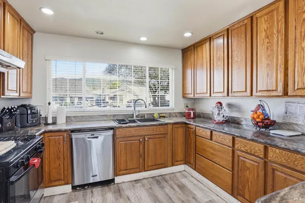 a kitchen with stainless steel appliances granite countertop a sink stove and cabinets
