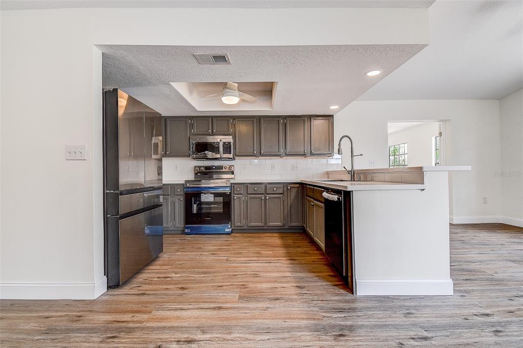 6234 Neff Lake Road Brooksville, FL 34601 - Photo 13 of 59 a kitchen with stainless steel appliances granite countertop a stove top oven a sink dishwasher and a refrigerator