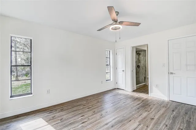 a view of a kitchen with wooden floor a sink a refrigerator and window