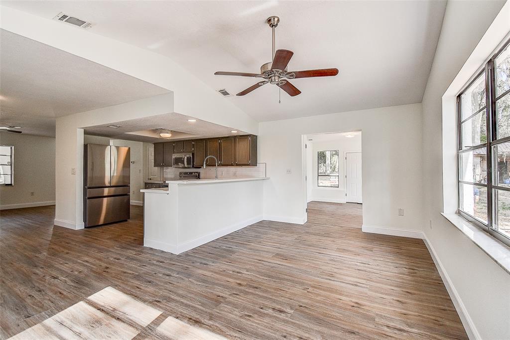 6234 Neff Lake Road Brooksville, FL 34601 - Photo 26 of 59 a view of a kitchen with wooden floor a sink a refrigerator and window