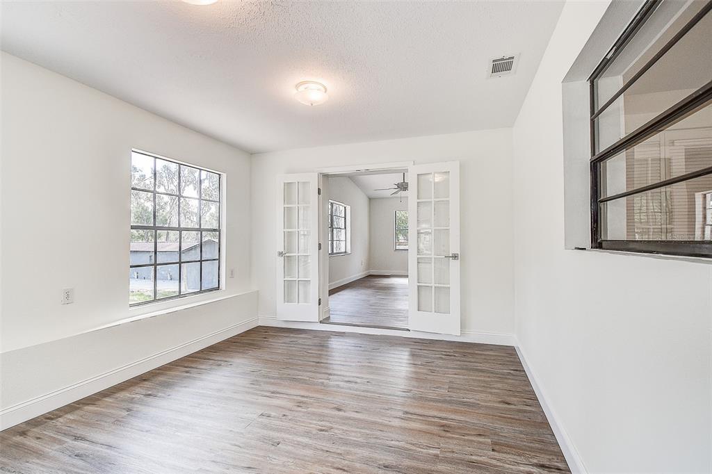 6234 Neff Lake Road Brooksville, FL 34601 - Photo 27 of 59 a view of an empty room with wooden floor and a window