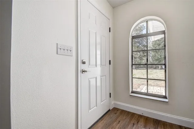 a view of empty room with wooden floor and ceiling fan