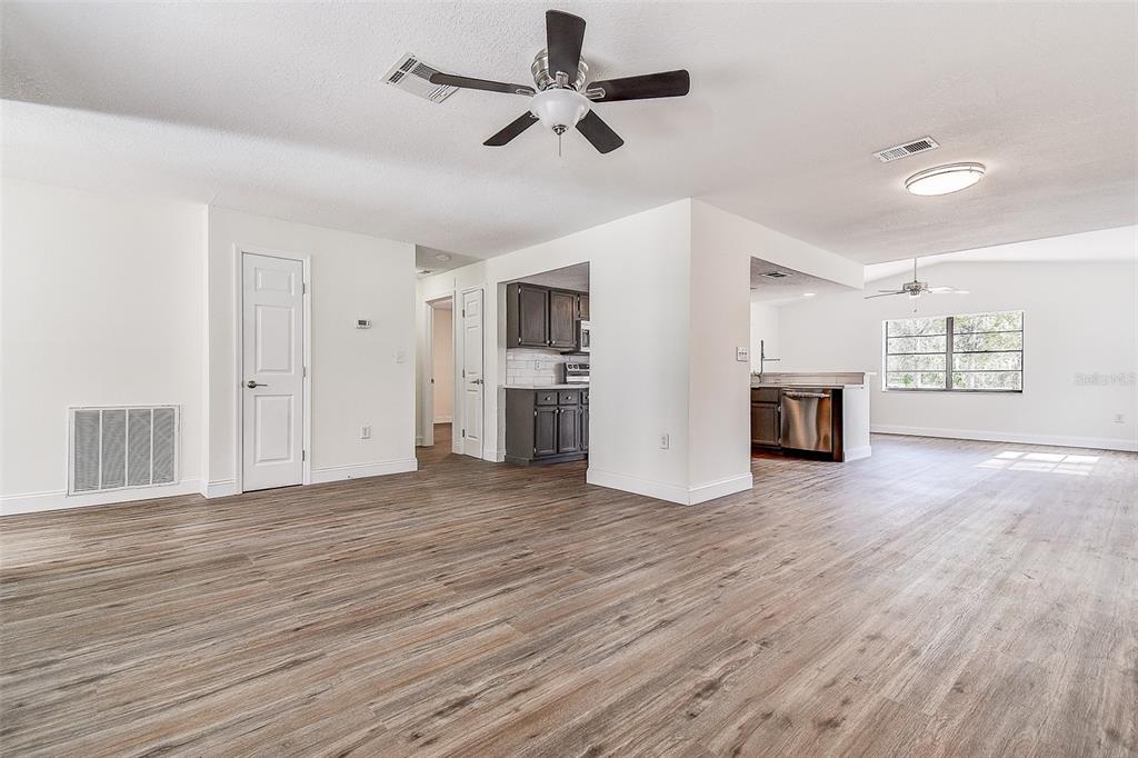 6234 Neff Lake Road Brooksville, FL 34601 - Photo 10 of 59 a view of empty room with wooden floor and ceiling fan