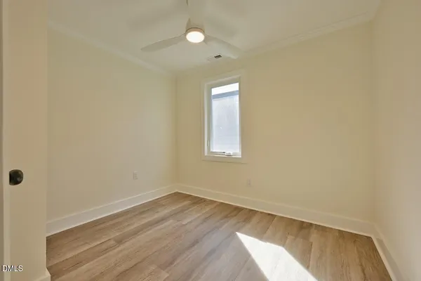 a view of a room with wooden floor and fan