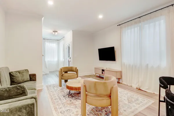 a kitchen with stainless steel appliances granite countertop a refrigerator a sink dishwasher a stove and white cabinets with wooden floor