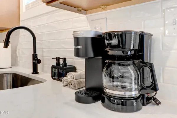 a bedroom with a bed and a lamp on dresser