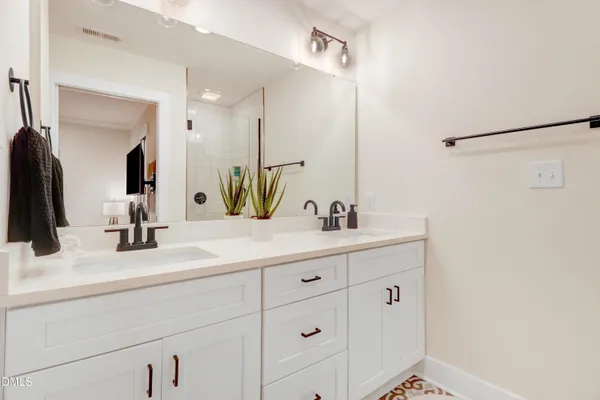 a bedroom with a white bed and a painting on the wall