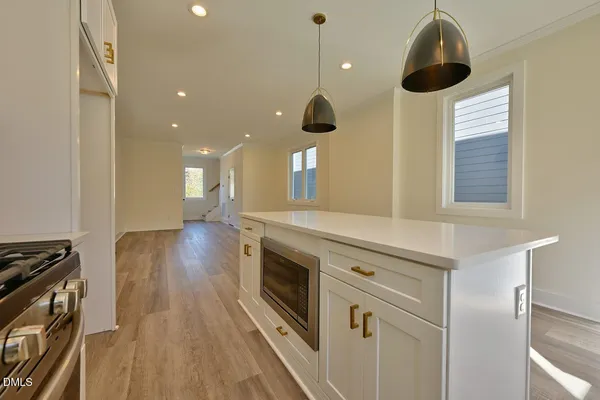 a kitchen with stainless steel appliances granite countertop a stove a sink and a wooden floors