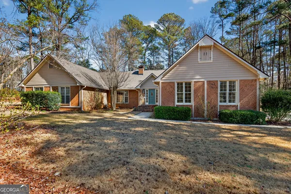 a front view of a house with a yard and trees