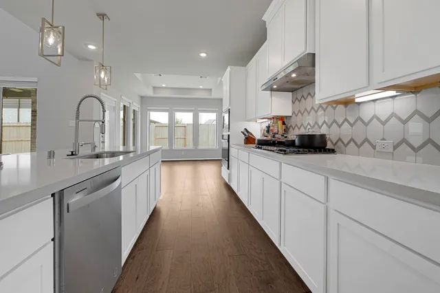 a kitchen with stainless steel appliances a sink stove and cabinets