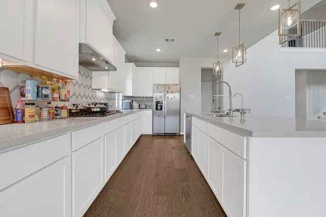 a large white kitchen with lots of counter space and a sink