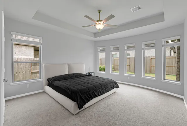 a spacious bedroom with a large bed and a large window