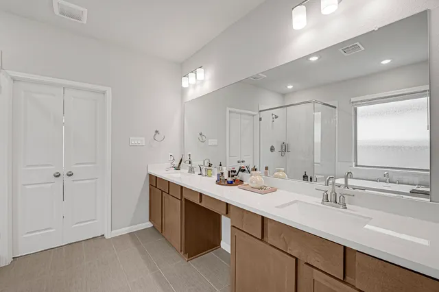 a bathroom with double sink and a mirror