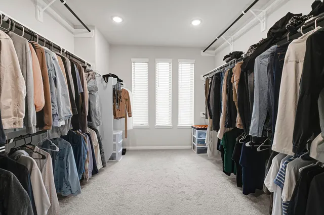 a view of walk in closet with clothes and shoes