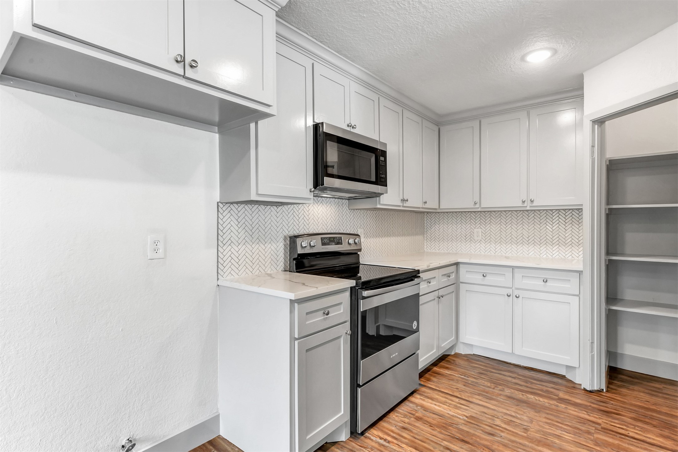 23118 Whispering Willow Drive Spring, TX 77373 - Photo 11 of 37 a kitchen with stainless steel appliances white cabinets and a stove top oven